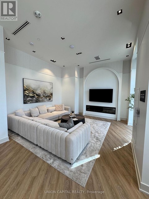 A modern living room with a large couch and a painting on the wall.