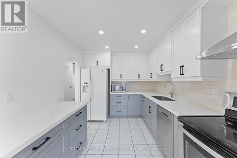 A kitchen with white cabinets and a black stove top oven.