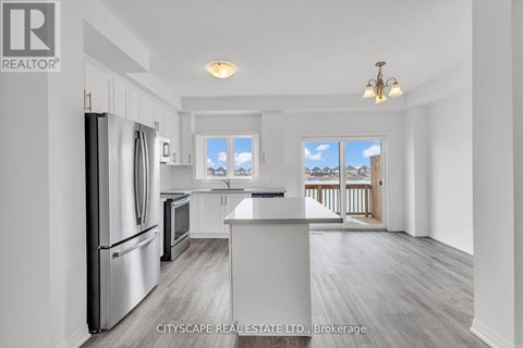 A kitchen with a refrigerator, oven, and microwave is on the left side of the image.