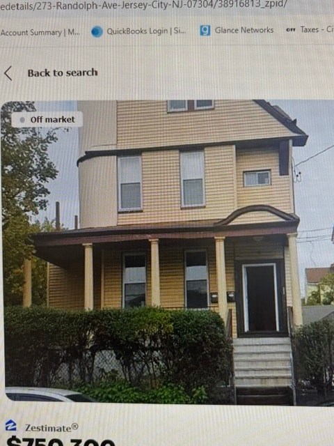 A two-story house with a porch and a front yard.