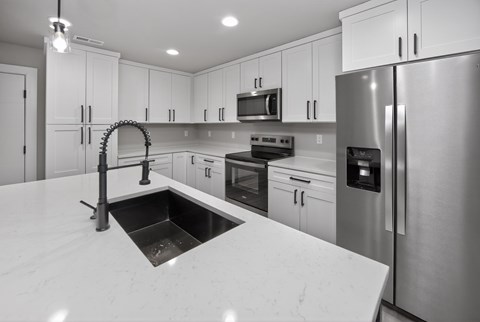 A modern kitchen with a sink and stainless steel appliances.