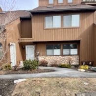 A brown house with a white door and windows.