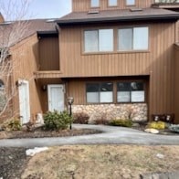 A brown house with a white door and windows.