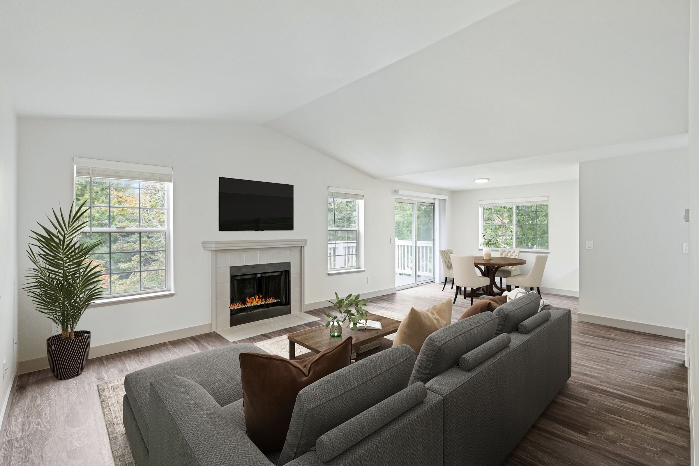 A living room with a grey couch and a fireplace.