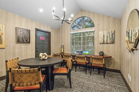 A dining room with a round table and chairs.