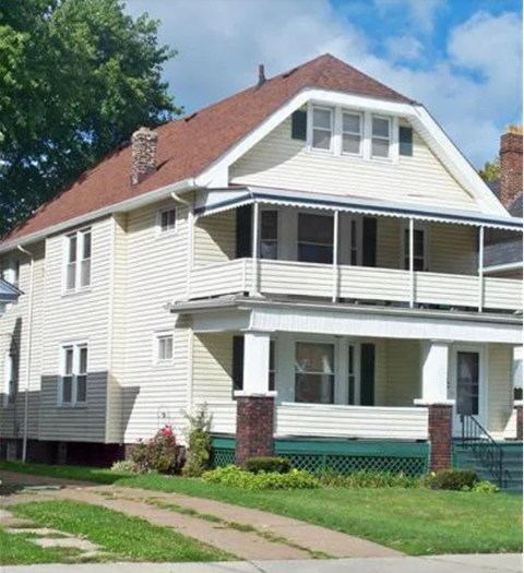 A two-story house with a white siding and a red roof.