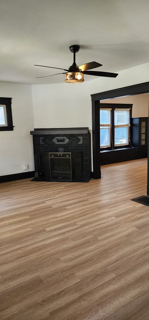 A room with a fireplace and a ceiling fan.