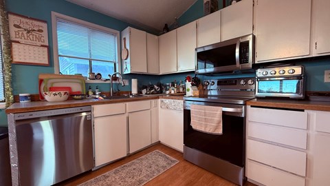 A kitchen with white cabinets and a stainless steel oven.