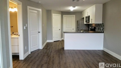A kitchen area with a white counter and a fridge.
