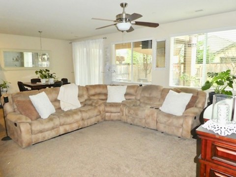 A beige couch with white pillows sits in a living room.