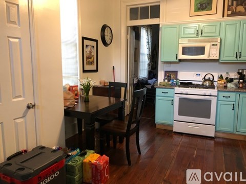 A kitchen with a table and chairs in front of it.
