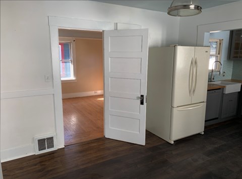A white refrigerator is in a kitchen with a door open.