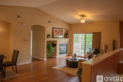 A living room with a brown sofa and a wooden floor.