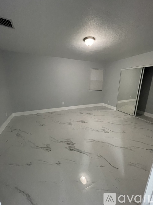A room with a marble floor and a ceiling light.