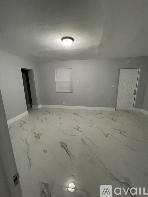 A room with a marble floor and a white door.