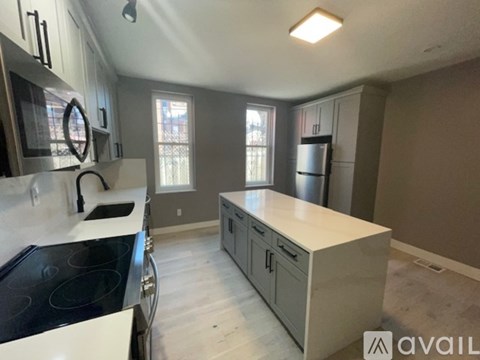 A kitchen with a stove top oven and a refrigerator.