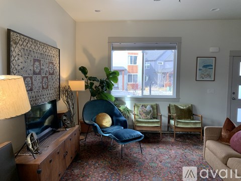 A living room with a blue chair and a gold ball on it.