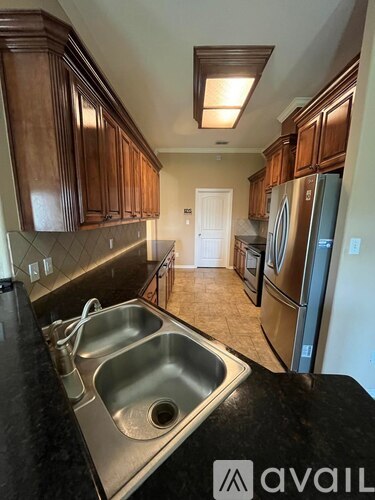 A kitchen with a sink and refrigerator.