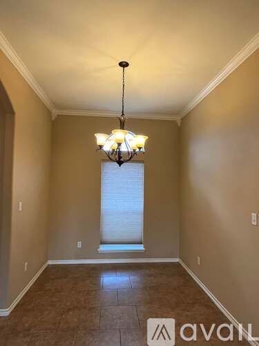 A room with a chandelier and a window.