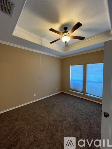 A room with a ceiling fan and a door leading to a balcony.