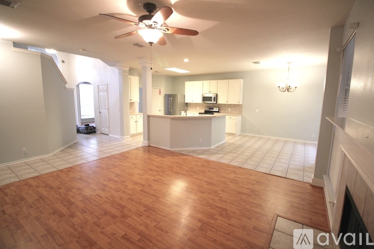 A living room with a ceiling fan and hardwood floors.