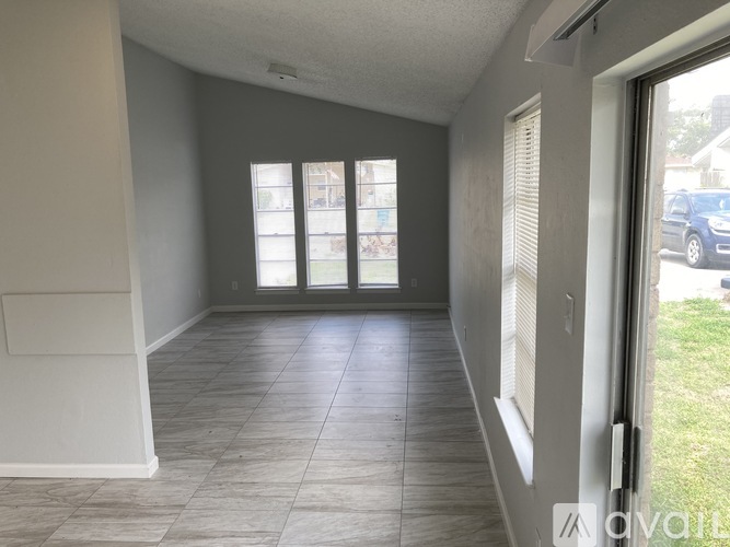A room with tiled flooring and a sliding glass door.