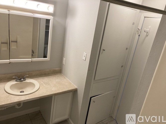 A bathroom with a sink, mirror, and shower stall.