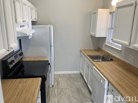 A kitchen with white cabinets and a black stove top oven.