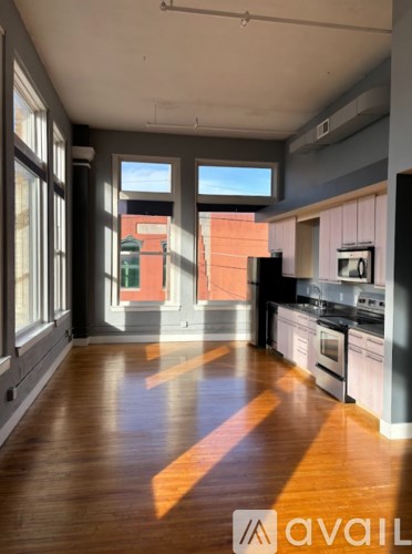 A kitchen with wooden floors and a large window.