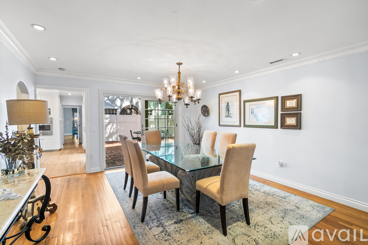 A modern dining room with a glass table and chairs.