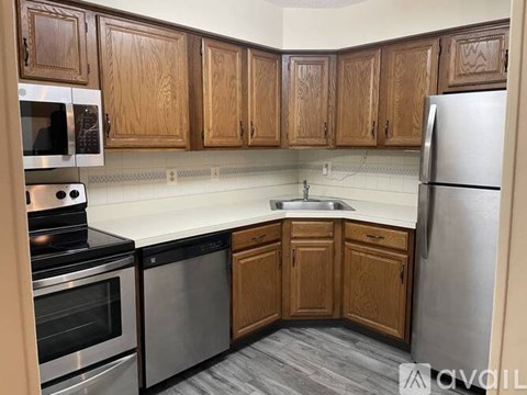 A kitchen with wooden cabinets and stainless steel appliances.