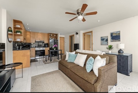 A modern living room with a brown couch and a ceiling fan.