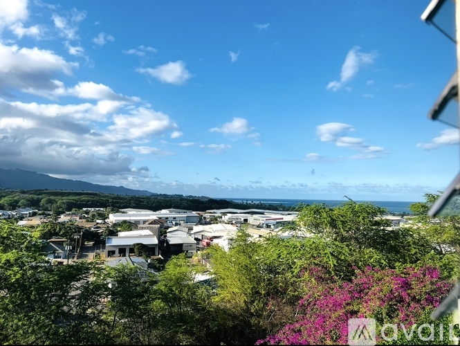 A view of a town with buildings and trees in the foreground and a mountain in the distance.