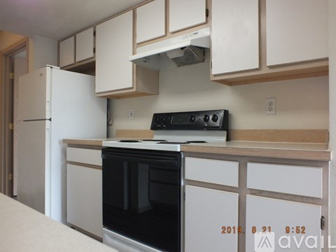 A kitchen with a black oven and white cabinets.
