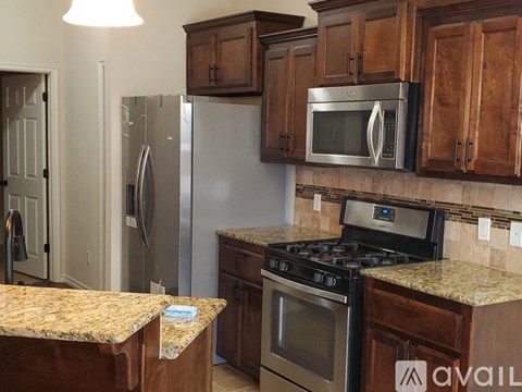A kitchen with granite countertops and stainless steel appliances.