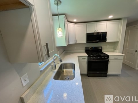 A kitchen with a black stove and white cabinets.