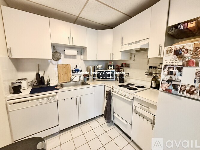 A kitchen with white cabinets and appliances.