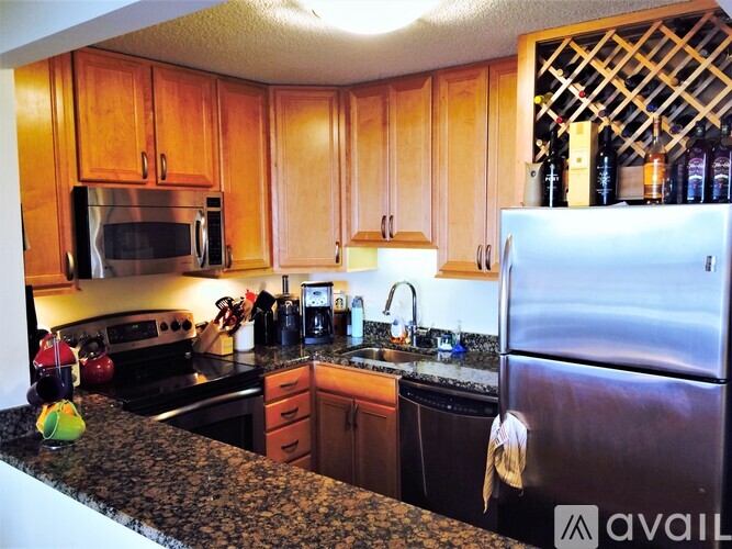 A kitchen with wooden cabinets and a granite countertop.