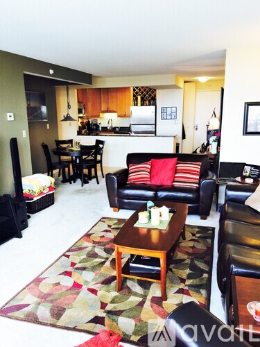 A living room with a black couch and a wooden coffee table.