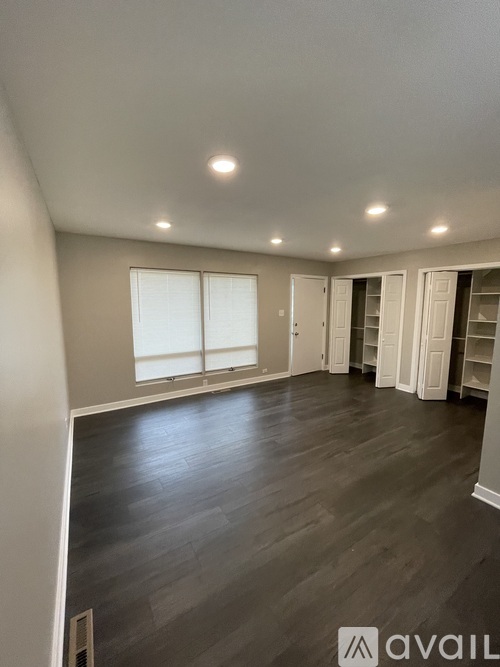 A spacious room with grey flooring and white walls.