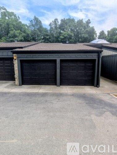 A two-car garage with a brown roof and a driveway in front.