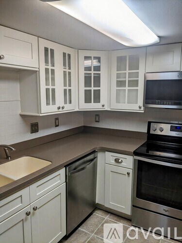 A kitchen with white cabinets and a stainless steel oven.