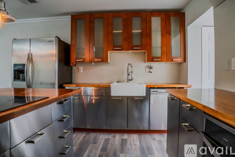 A kitchen with wooden cabinets and a stainless steel refrigerator.