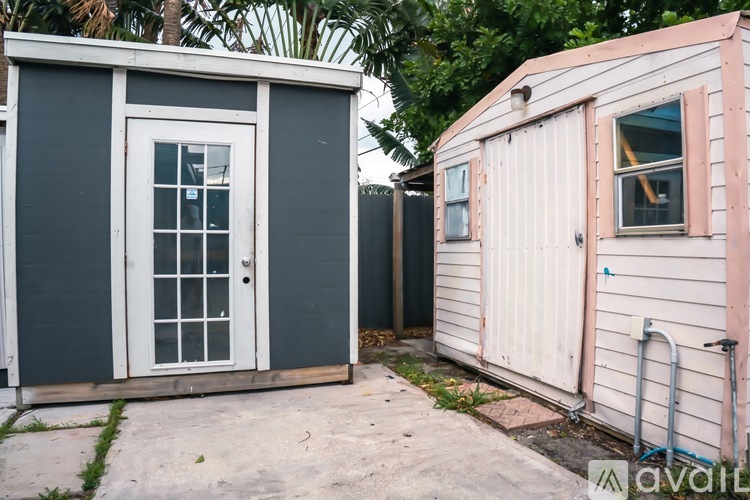 Two small buildings with one having a door and the other having a window.
