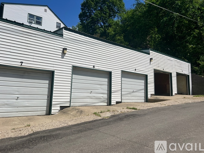 A building with a white facade and three closed garage doors.