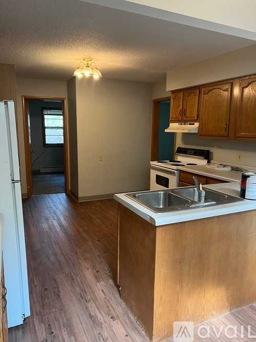 A kitchen with wooden cabinets and a white fridge.