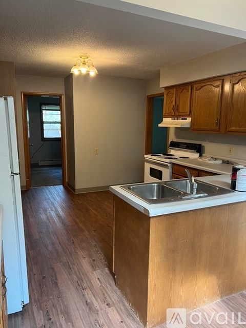 A kitchen with wooden cabinets and a white fridge.