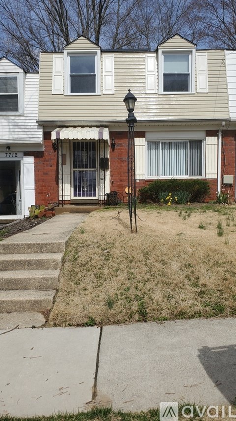 A house with a brown door and a lamp post in front.