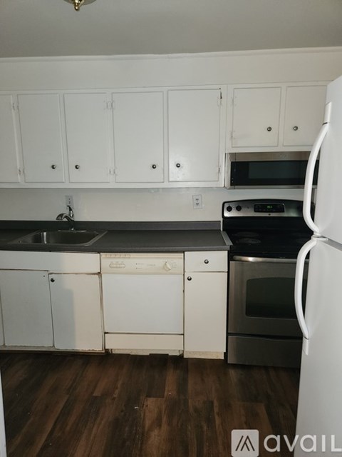 A kitchen with white cabinets and a white refrigerator.