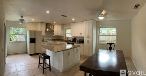 A kitchen with white cabinets and a wooden table.